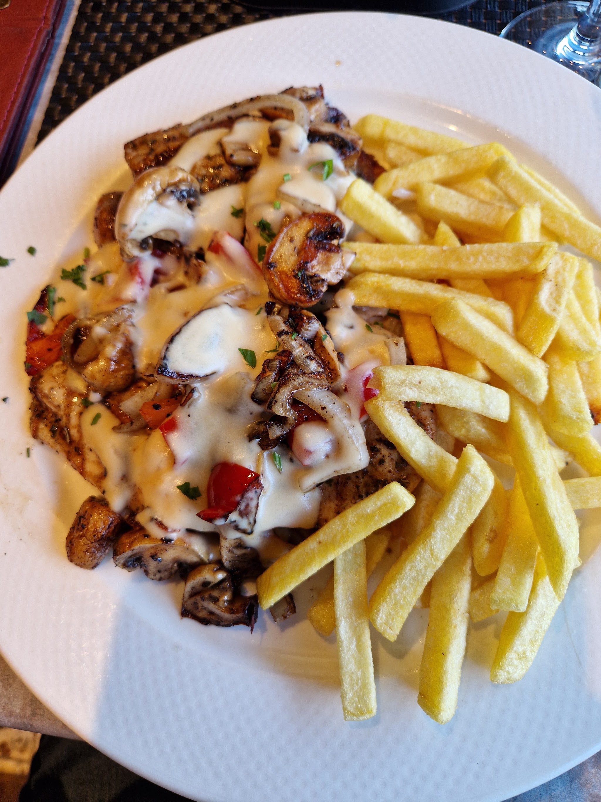 Gegrild vlees met champignons, paprika en roomsaus, met friet