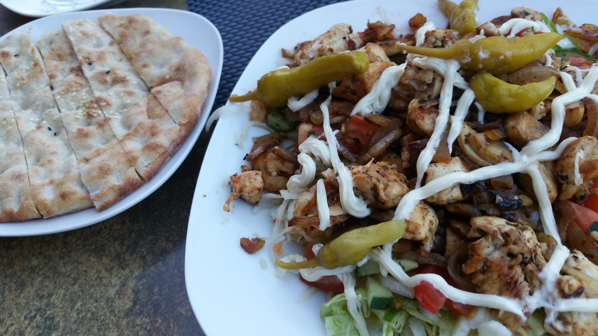Bord gyros met knoflooksaus, pepperoncini en sesambrood bij Grill-bistro Markiz